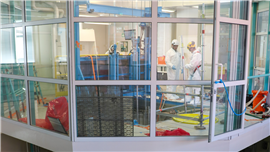 In the research space located above the reactor, preparations being made to transfer the radioactive heart component to the lower level of the building through the open door visible on the right side of the picture.