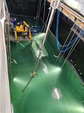 A metal component is lifted out of the water-flooded reactor vessel.