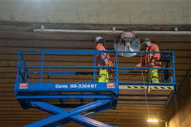 Workers on a scissorlift carrying out concrete cutting on the underside of a viaduct