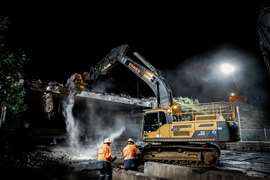 An excavator demolishing a bridge