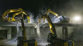 Five excavators with hammer attachments demolishing the 980-tonne bridge