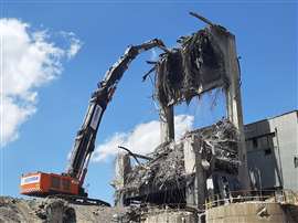 A high reach excavator demolishes part of the La Robla Thermal Power Plant