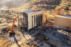 An excavator demplishes a structure on the Argyle Diamond Mine site