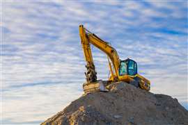 Unbranded yellow excavator on a mound of earth