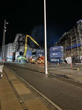 A J Jensen long reach Caterpillar works at night to remove part of the scaffolding