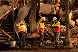 Los Angeles Department of Water and Power personnel work near the remains of a business destroyed by the Palisades Fire in the Pacific Palisades neighborhood in Los Angeles, California, U.S. January 11, 2025. REUTERS/David Ryder