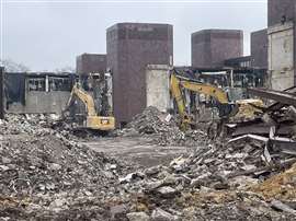 Demolition excavators sort through rubble and debris at the former Kmart site