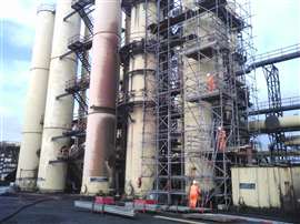 Workers on scaffolding performing steaming and chemical dosing at 