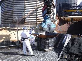 Workers dealing with hazardous waste materials at the Benzol Tank